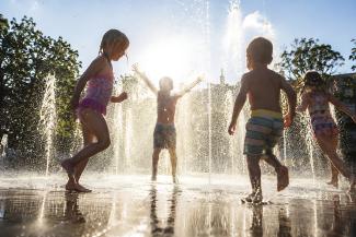 Children playing at a water playparc in sunlight (ai generated)