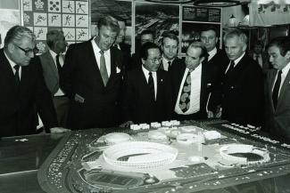 Businessman discussing sports stadium architecture model
